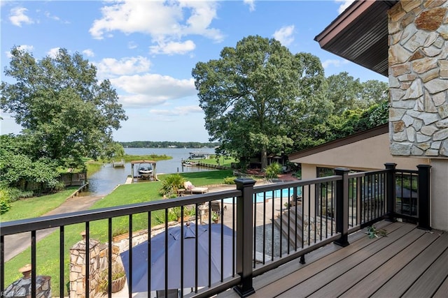 wooden deck featuring a water view and a lawn