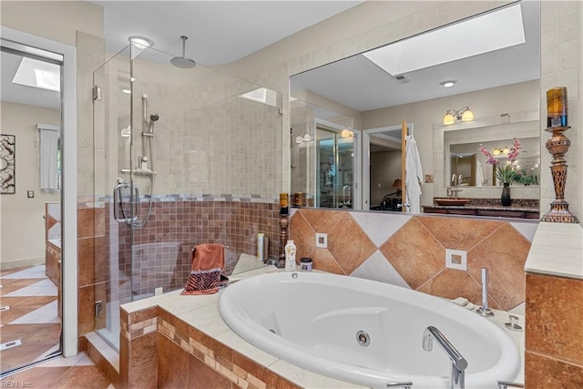 bathroom with a skylight, a shower stall, a whirlpool tub, and vanity