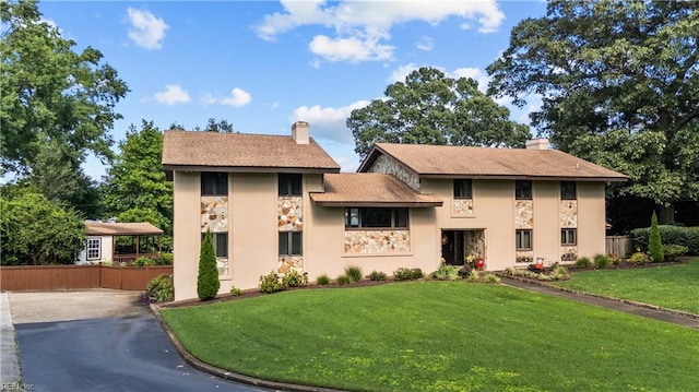 view of front of property with stone siding, a chimney, driveway, and stucco siding