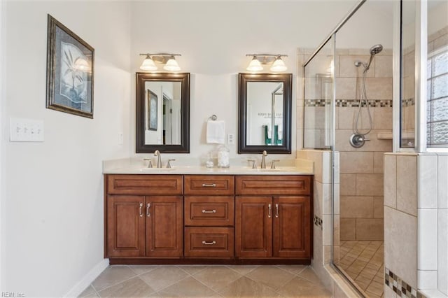bathroom with a stall shower, double vanity, tile patterned floors, and baseboards