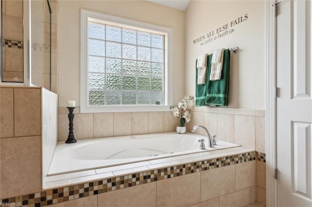 bathroom with plenty of natural light and a garden tub