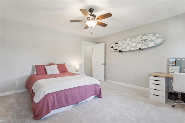 bedroom with light colored carpet, baseboards, a desk, and a ceiling fan