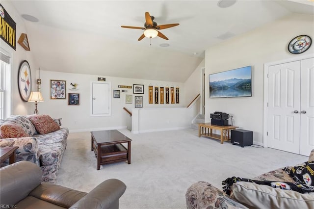 carpeted living area with lofted ceiling, a ceiling fan, baseboards, and stairs