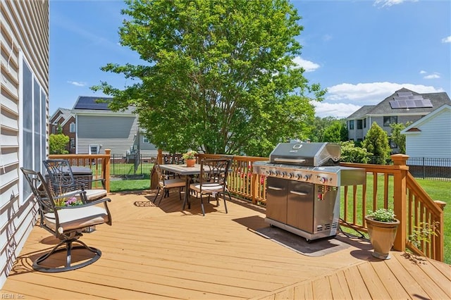 wooden terrace featuring outdoor dining area and grilling area