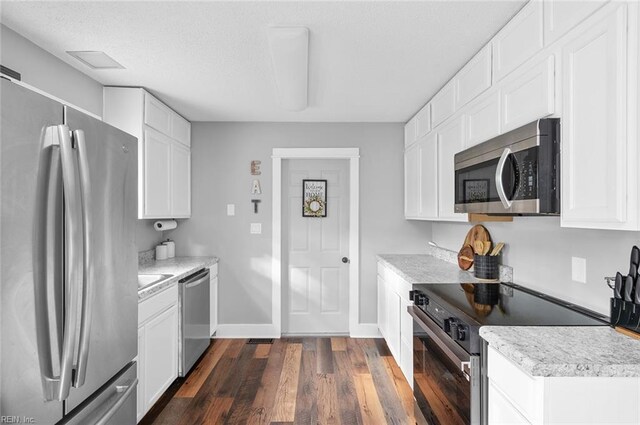 8209 Harlan Dr, Suffolk, VA 23436 - kitchen featuring appliances with stainless steel finishes, light countertops, dark wood finished floors, baseboards, and white cabinetry