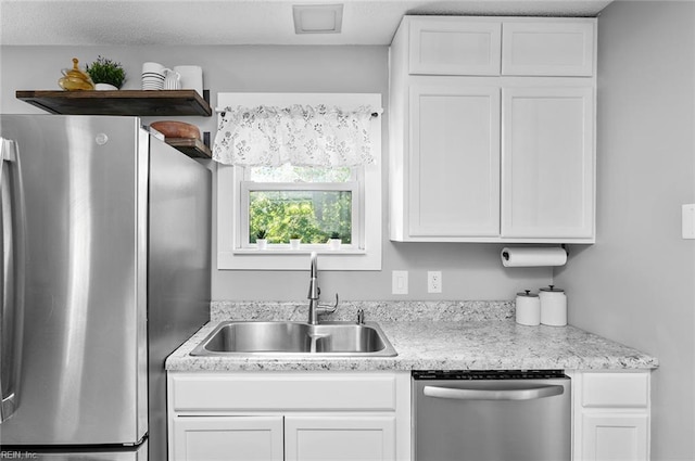 8209 Harlan Dr, Suffolk, VA 23436 - kitchen featuring appliances with stainless steel finishes, a sink, white cabinets, and light countertops