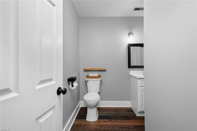 8209 Harlan Dr, Suffolk, VA 23436 - half bath with wood finished floors, vanity, toilet, and baseboards