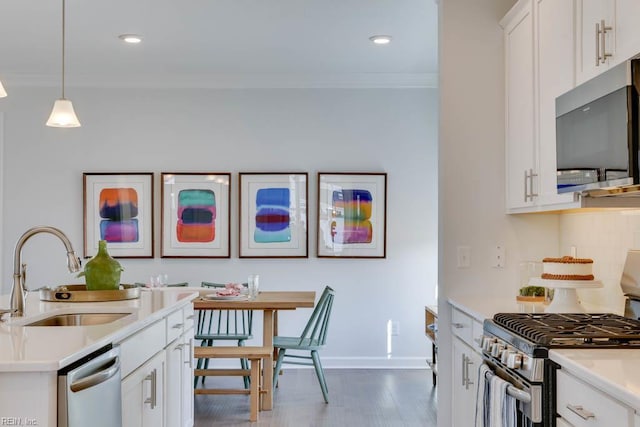 2234 Captiva Ln, Chesapeake, VA 23321 - kitchen featuring stainless steel appliances, a sink, ornamental molding, light countertops, and wood finished floors