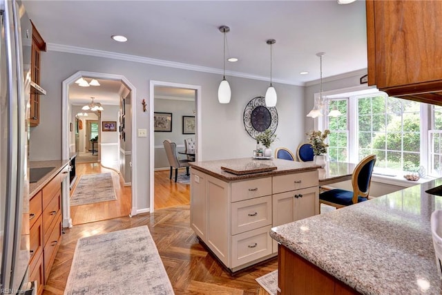 108 Devonshire Dr, Williamsburg, VA 23188 - kitchen with light stone counters, white cabinets, arched walkways, a center island, and ornamental molding