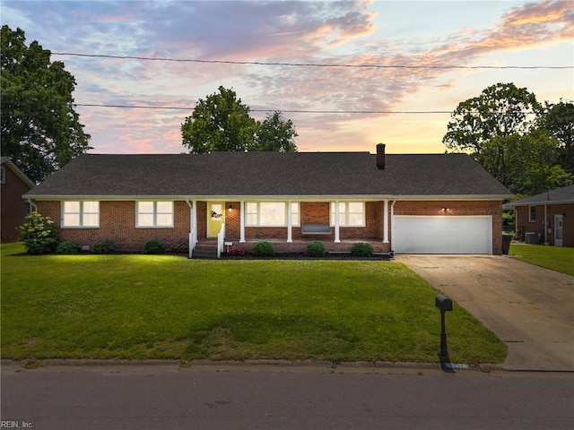 ranch-style home featuring concrete driveway, brick siding, a front lawn, and a garage