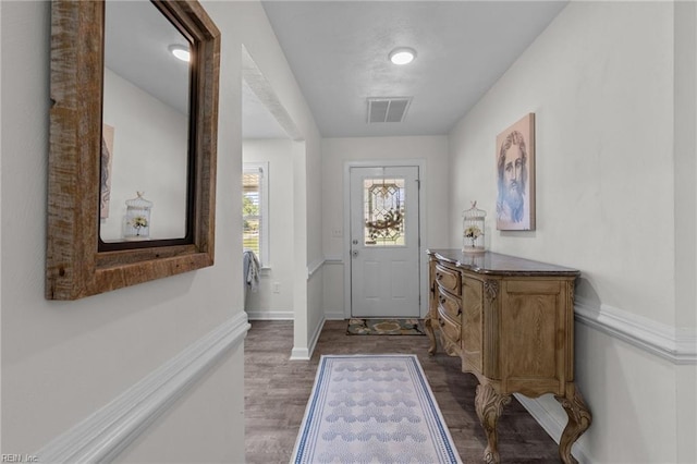 doorway featuring dark wood-style flooring and baseboards