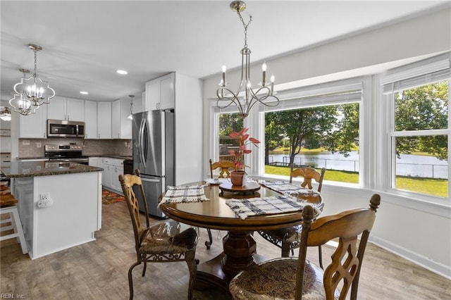 dining area featuring a chandelier, healthy amount of natural light, wood finished floors, baseboards, and recessed lighting