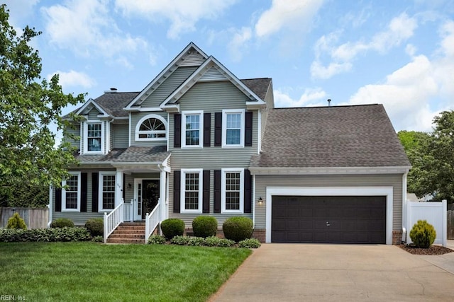 traditional-style home featuring driveway, an attached garage, and a shingled roof