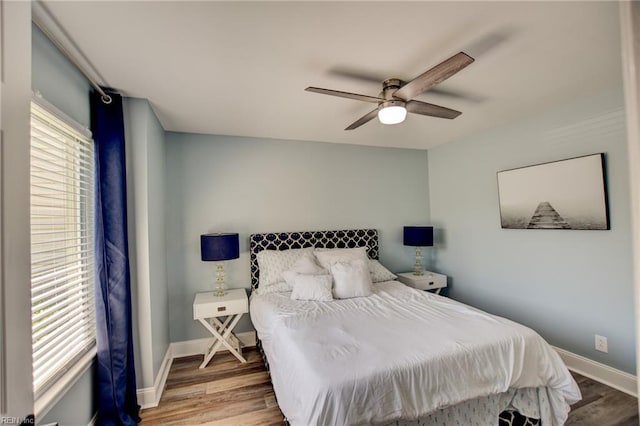 bedroom with wood finished floors, baseboards, and a ceiling fan