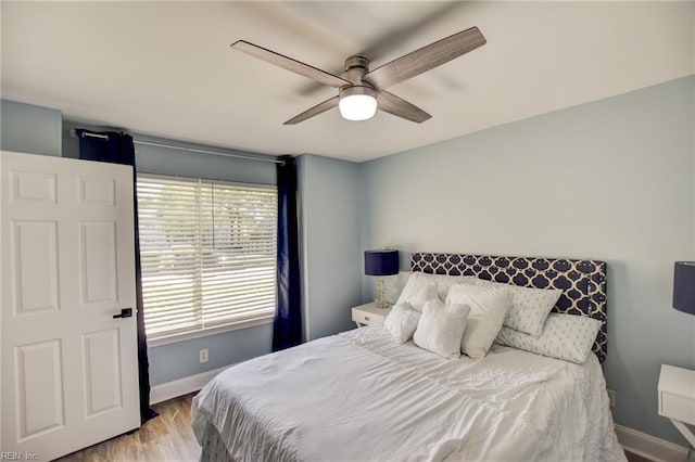 bedroom featuring baseboards, wood finished floors, and ceiling fan