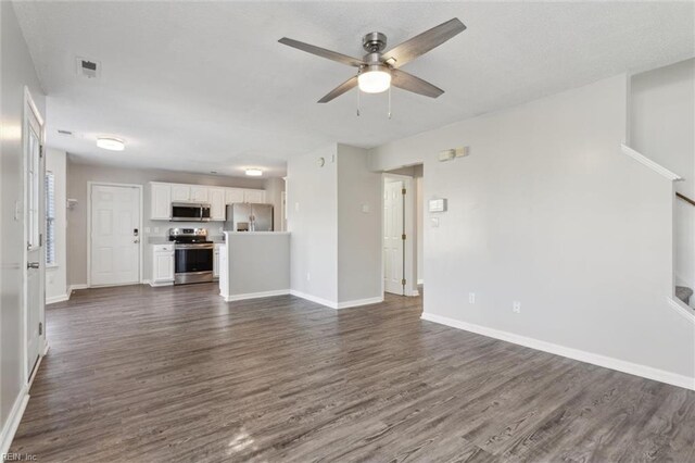 unfurnished living room featuring a ceiling fan, dark wood-style floors, and baseboards