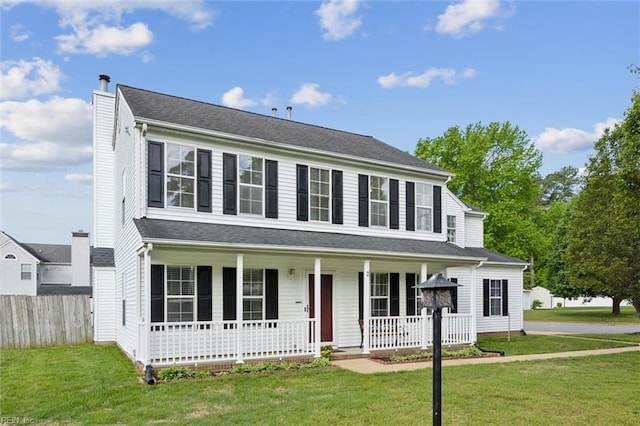 colonial inspired home featuring a porch and a chimney