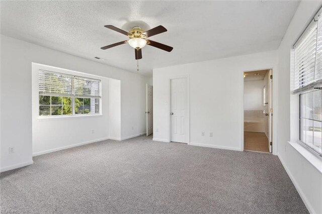 unfurnished bedroom with carpet floors, ensuite bathroom, baseboards, and ceiling fan