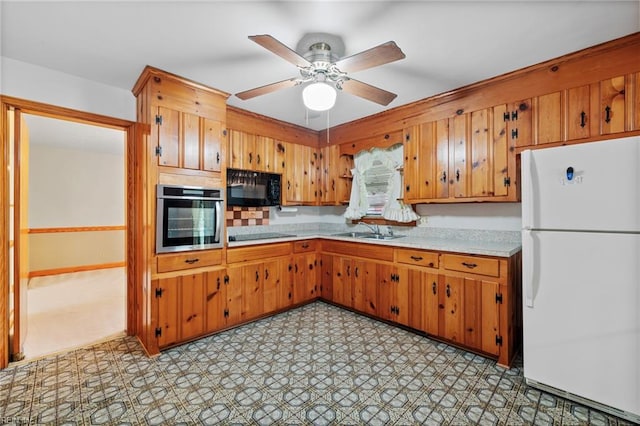 2916 Taylor Rd, Chesapeake, VA 23321 - kitchen featuring black appliances, light countertops, a sink, brown cabinets, and light flooring