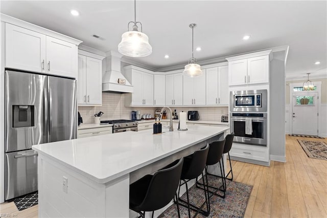 2349 Treesong Trl, Virginia Beach, VA 23456 - kitchen with appliances with stainless steel finishes, custom range hood, white cabinets, decorative backsplash, and an island with sink