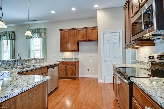 1429 Blairwood Ln Unit 117, Chesapeake, VA 23320 - kitchen featuring stainless steel appliances, a sink, brown cabinetry, light wood-style flooring, and decorative light fixtures