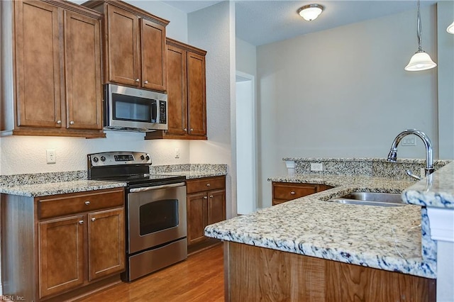 1429 Blairwood Ln Unit 117, Chesapeake, VA 23320 - kitchen featuring stainless steel appliances, a sink, wood finished floors, pendant lighting, and light stone countertops