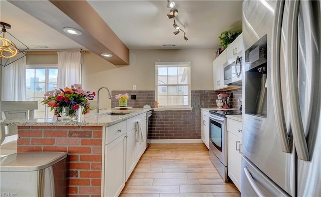 100 Castilian Dr, Virginia Beach, VA 23462 - kitchen with stainless steel appliances, a sink, light wood-style flooring, white cabinets, and light stone counters