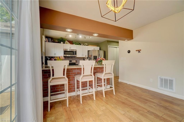 100 Castilian Dr, Virginia Beach, VA 23462 - dining room featuring light wood-style floors, baseboards, a chandelier, and track lighting