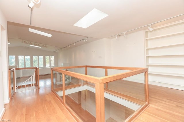 6025 River Rd, Norfolk, VA 23505 - hall featuring rail lighting, an upstairs landing, wood finished floors, a skylight, and vaulted ceiling