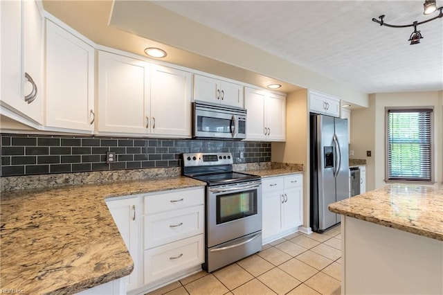 kitchen with appliances with stainless steel finishes, light tile patterned floors, and white cabinets