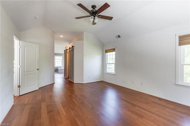 bonus room with vaulted ceiling, wood finished floors, ceiling fan, baseboards, and a barn door