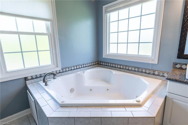 bathroom featuring plenty of natural light, vanity, and a jetted tub