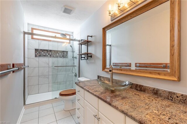 full bath with toilet, tile patterned flooring, tiled shower, and vanity