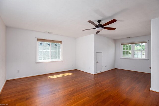 empty room with wood finished floors, ceiling fan, and baseboards