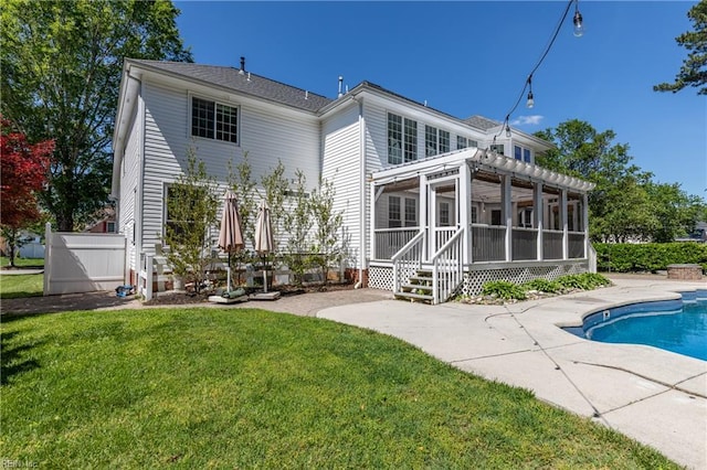 back of house with a sunroom, a patio area, and an outdoor pool