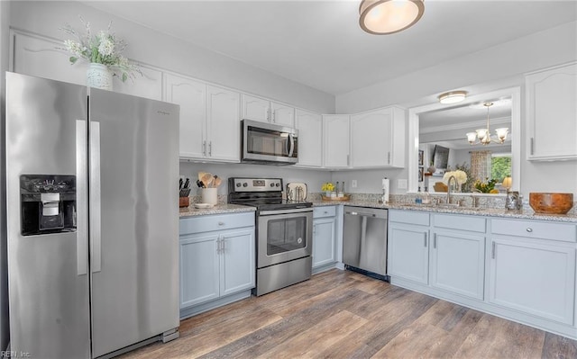 8 Riverview Ct, Suffolk, VA 23434 - kitchen with stainless steel appliances, a sink, white cabinets, a chandelier, and wood finished floors