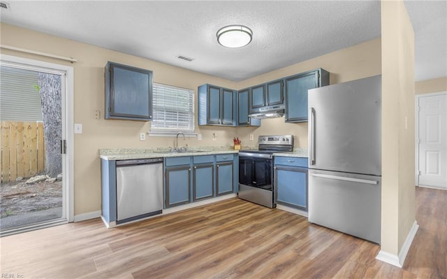 187 N Hunt Club Run, Newport News, VA 23608 - kitchen featuring appliances with stainless steel finishes, a sink, under cabinet range hood, wood finished floors, and blue cabinets