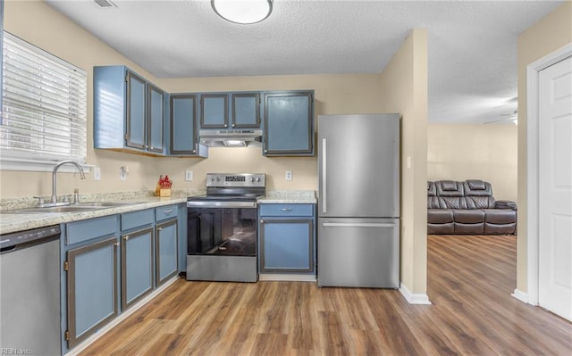 187 N Hunt Club Run, Newport News, VA 23608 - kitchen featuring stainless steel appliances, under cabinet range hood, a sink, wood finished floors, and light countertops