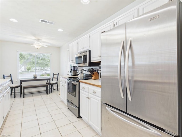 kitchen with appliances with stainless steel finishes, light countertops, white cabinets, a ceiling fan, and light tile patterned flooring