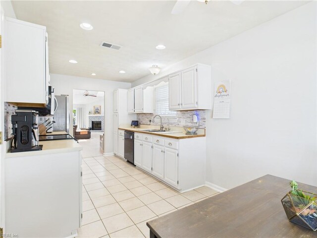 kitchen with dishwasher, a sink, ceiling fan, decorative backsplash, and light tile patterned floors