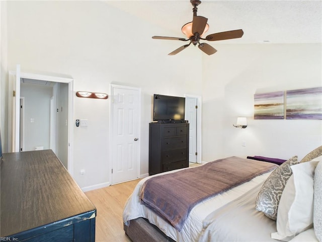 bedroom with high vaulted ceiling, wood finished floors, baseboards, and ceiling fan