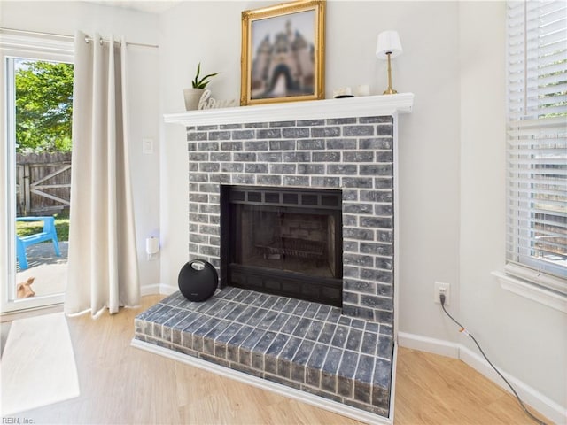 detailed view of wood finished floors, a fireplace, and baseboards