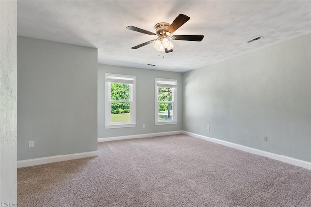 carpeted empty room with baseboards and a ceiling fan