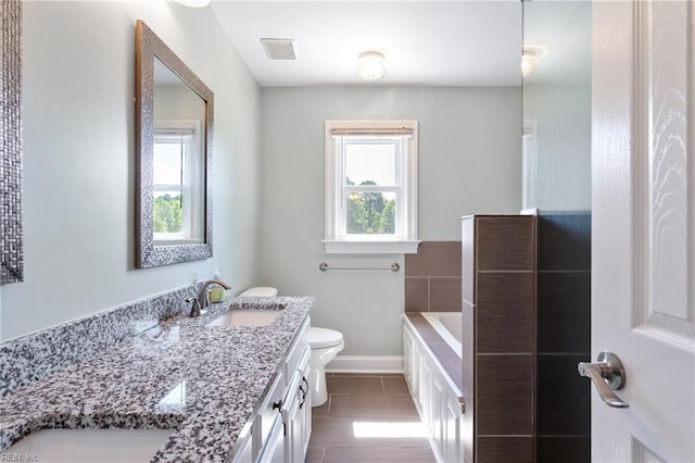 full bath with toilet, a garden tub, vanity, baseboards, and tile patterned floors