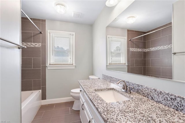 bathroom featuring plenty of natural light, tile patterned flooring, vanity, and toilet