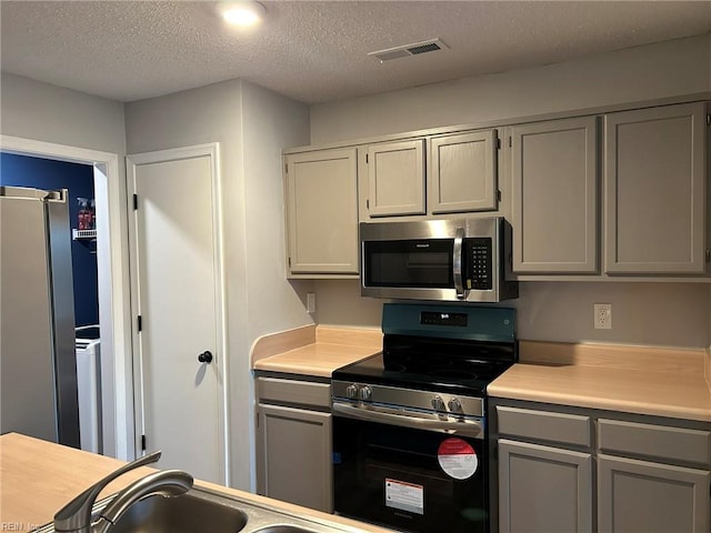 5049 Heathglen Cir, Virginia Beach, VA 23456 - kitchen with stainless steel appliances, light countertops, gray cabinets, a textured ceiling, and a sink