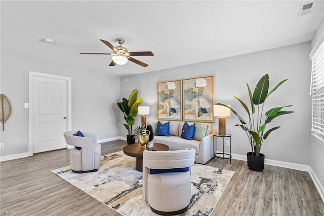 sitting room featuring wood finished floors, ceiling fan, healthy amount of natural light, and baseboards