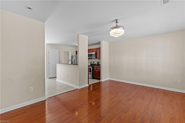 515 Battery Ave, Suffolk, VA 23434 - unfurnished living room featuring light wood-style flooring, baseboards, and a chandelier