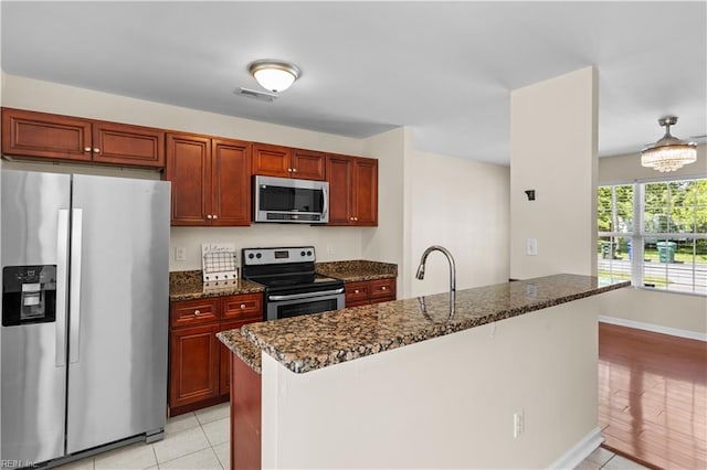 515 Battery Ave, Suffolk, VA 23434 - kitchen featuring stainless steel appliances, light tile patterned floors, dark stone counters, a sink, and baseboards