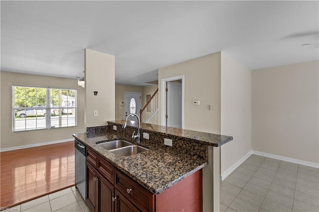 515 Battery Ave, Suffolk, VA 23434 - kitchen featuring a sink, dishwasher, light tile patterned floors, baseboards, and dark stone countertops